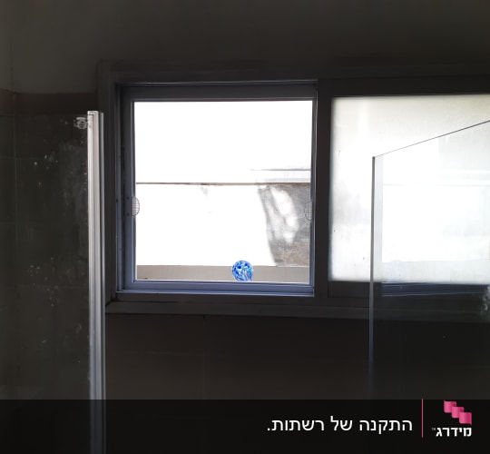 חלון אלומיניום עם מסגרת כסופה בחדר אמבטיה